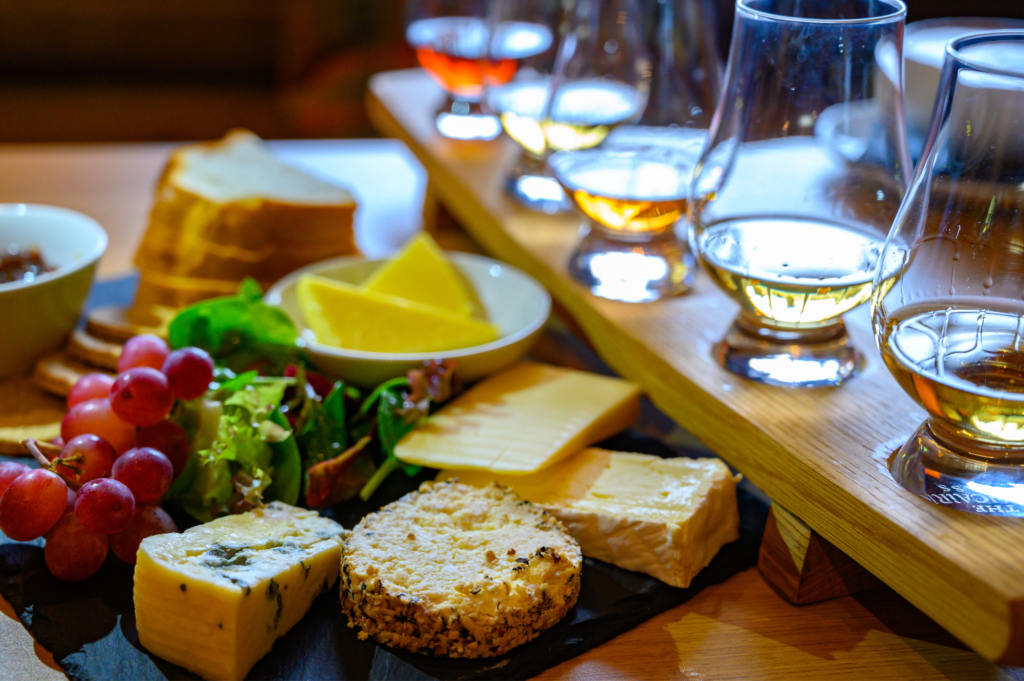 plateau de dégustation de whisky accompagné de fromages et d'autre nourriture